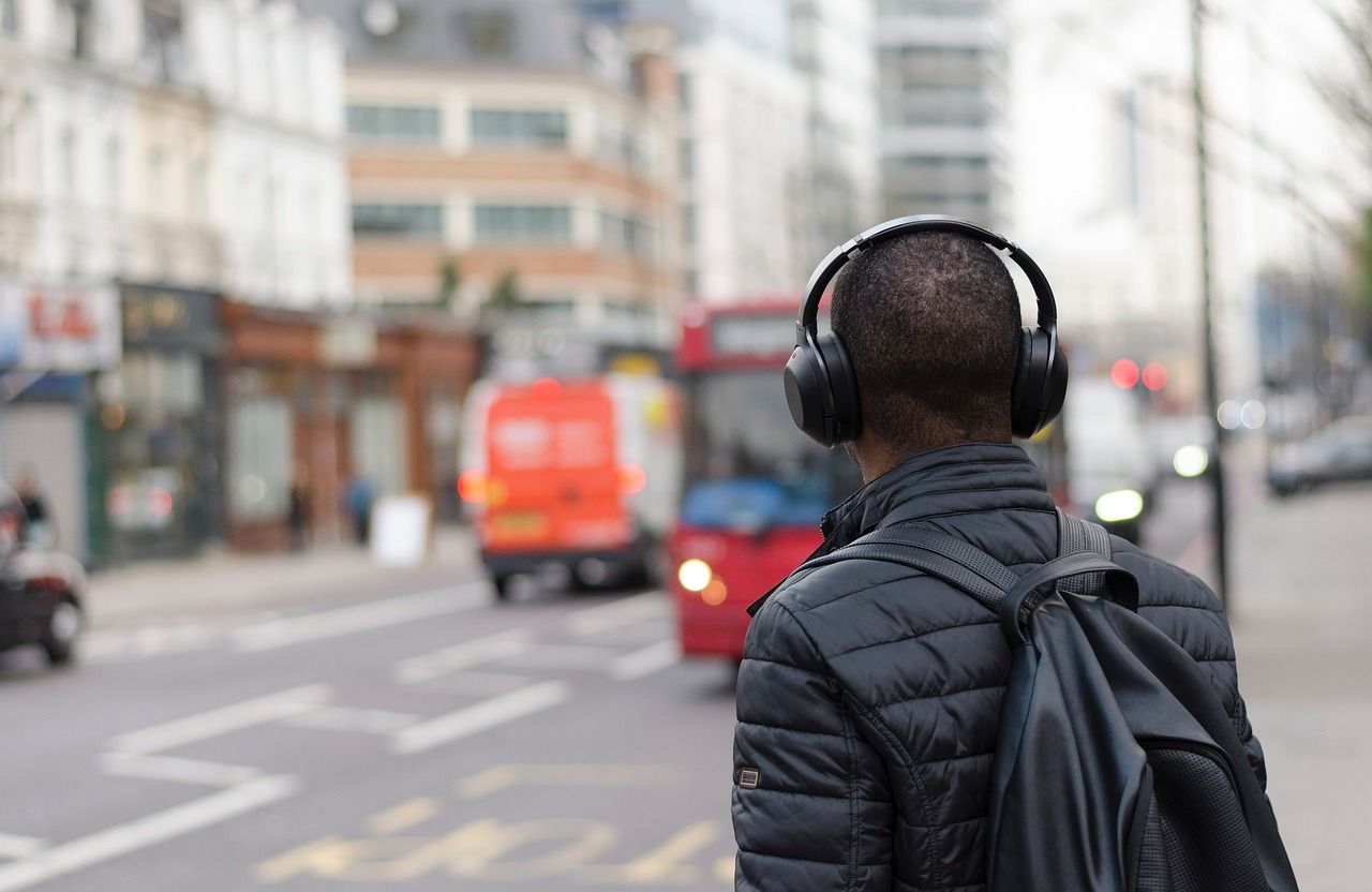 Man listening to headphones at a bus stop